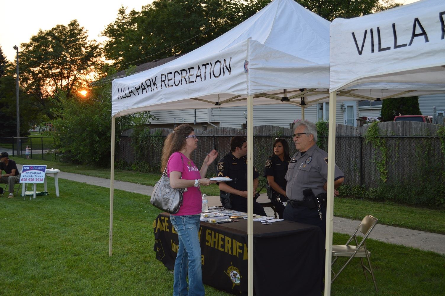 Village President Deborah Bullwinkel talks with members of the DuPage County Sheriff's Department at a National Night Out event at the Iowa Community Center, Aug. 2.